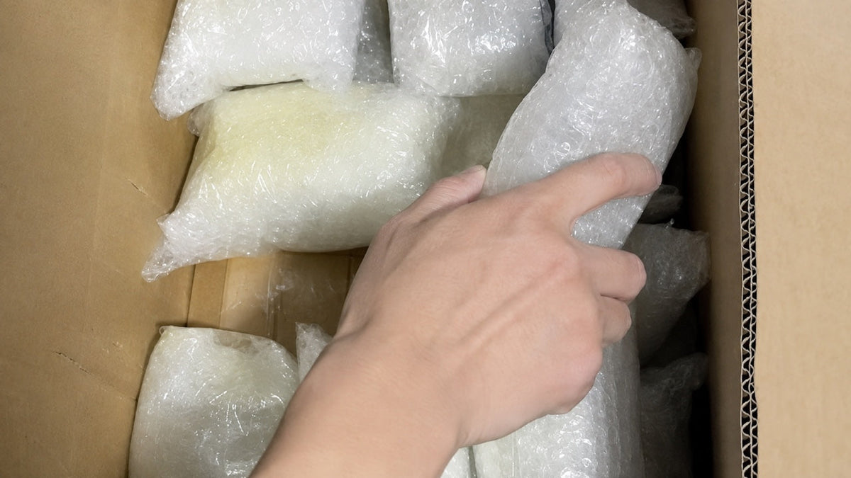 Individually wrapped wholesale crystal products being arranged in a protective shipping carton.